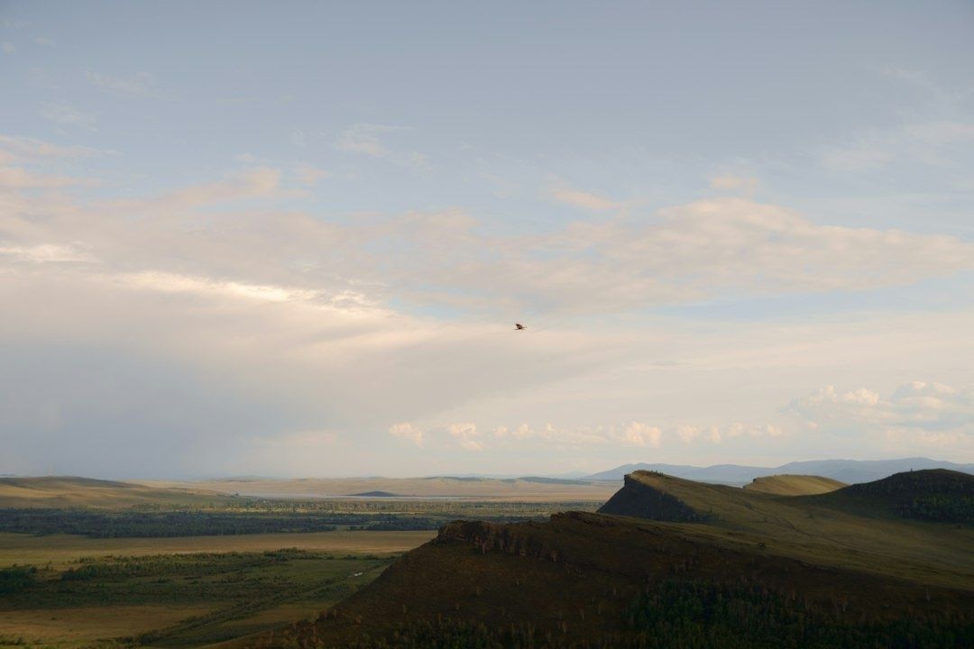 Lite fly over et åpent fjellandskap med dal og fjellrygger